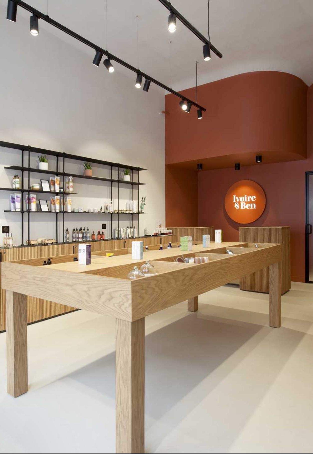 Boutique commerciale après aménagement avec comptoir bois, étagères et éclairage sur rail