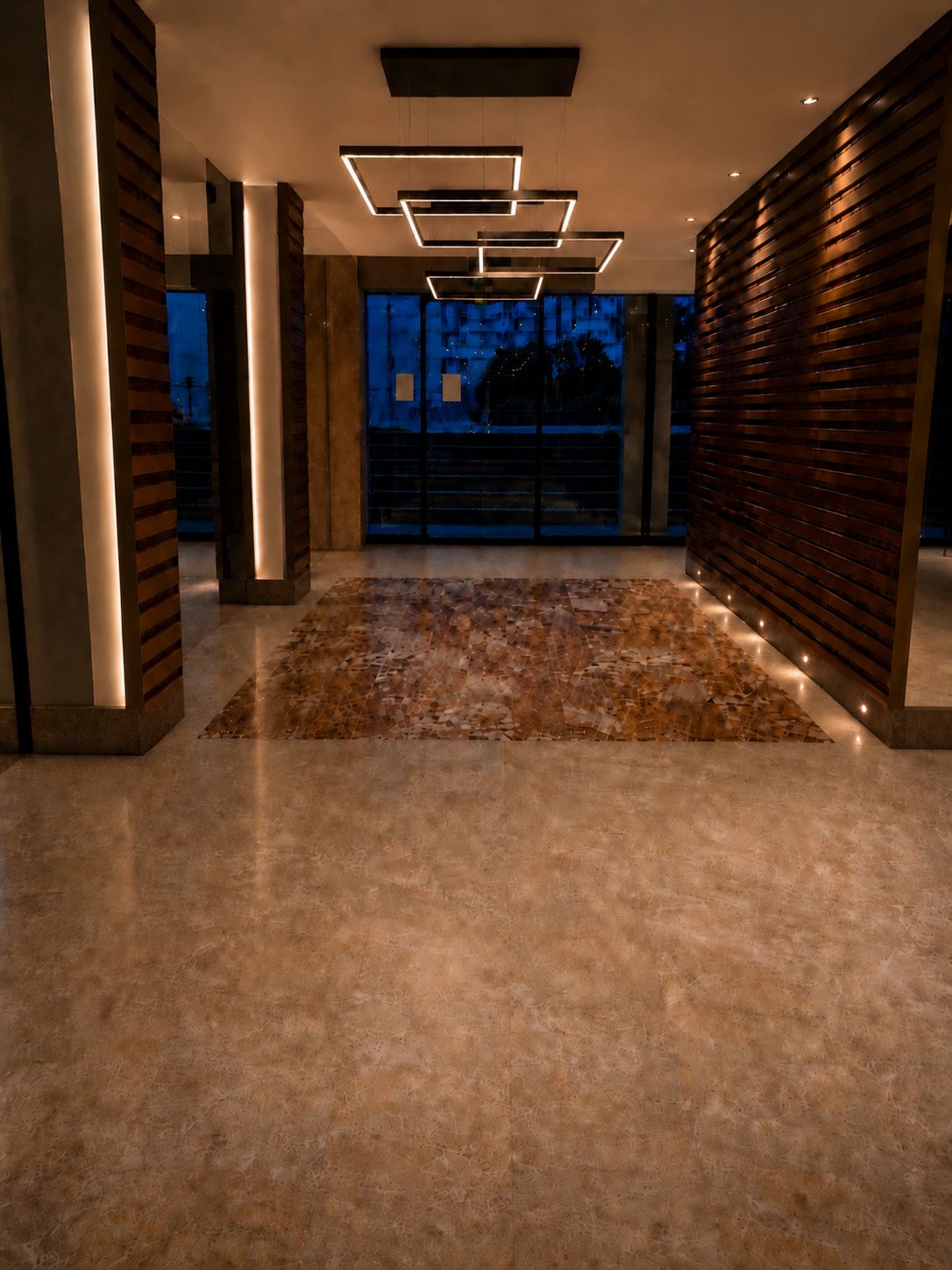 Hall de copropriété rénové avec marbre poli et éclairage architectural